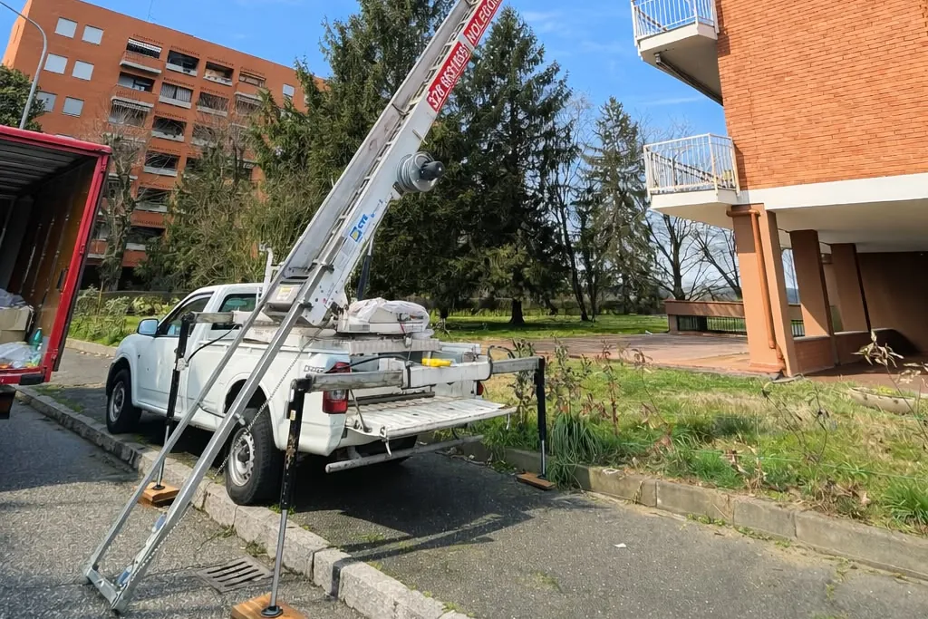 Pick-up Dergesat con autoscala accanto a un condominio