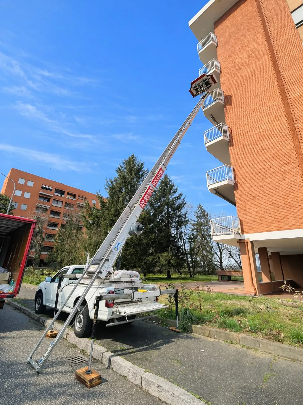 Autoscala Dergesat al lavoro sulla facciata di un palazzo